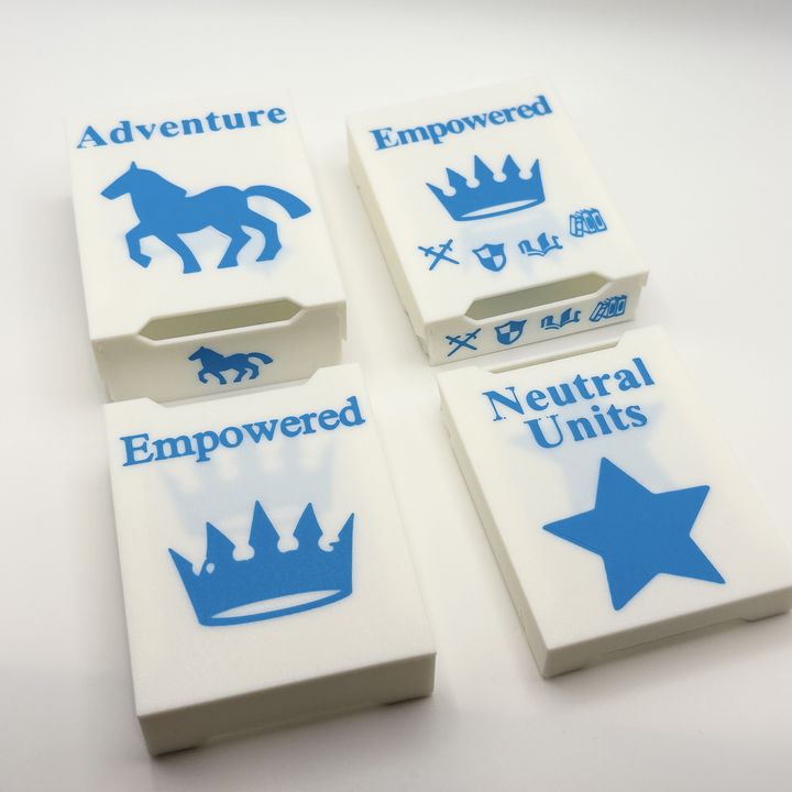 White board-game card boxes with blue printed icons: a horse, two crowns and a star